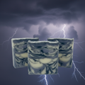 Three Electric Storm handmade cold process soap bars with indigo and charcoal swirls against a dramatic thunderstorm background